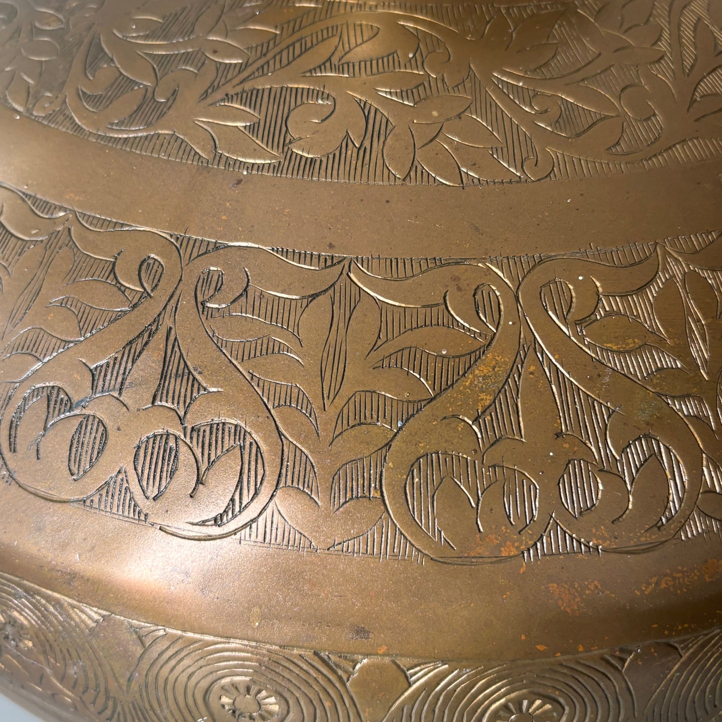 Detail of wave band and rosette motifs on antique brass pot