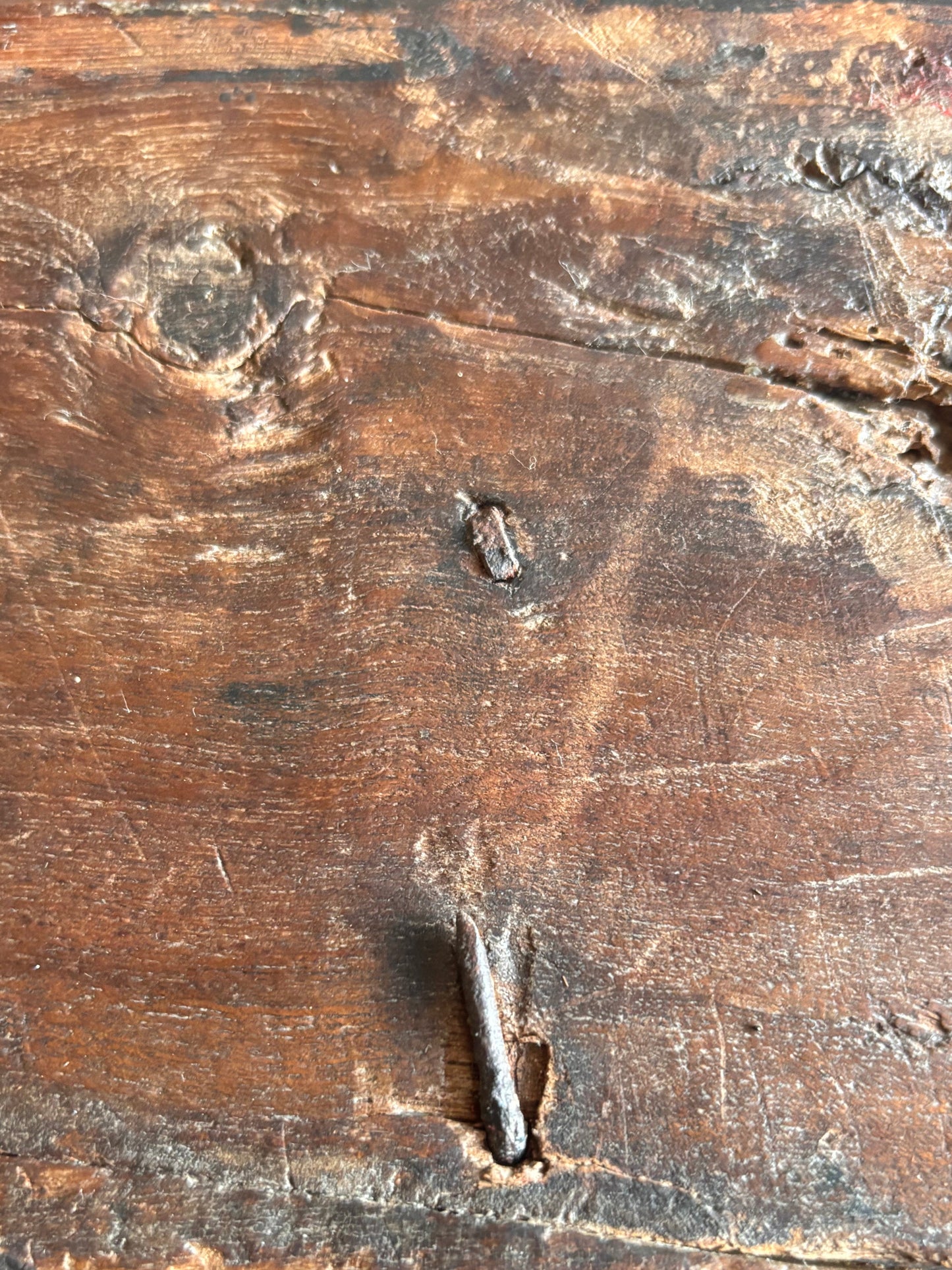 Inside view of antique carved wooden dowry box with forged iron carry handle showing hand forged fixing with newer machine forged repair.