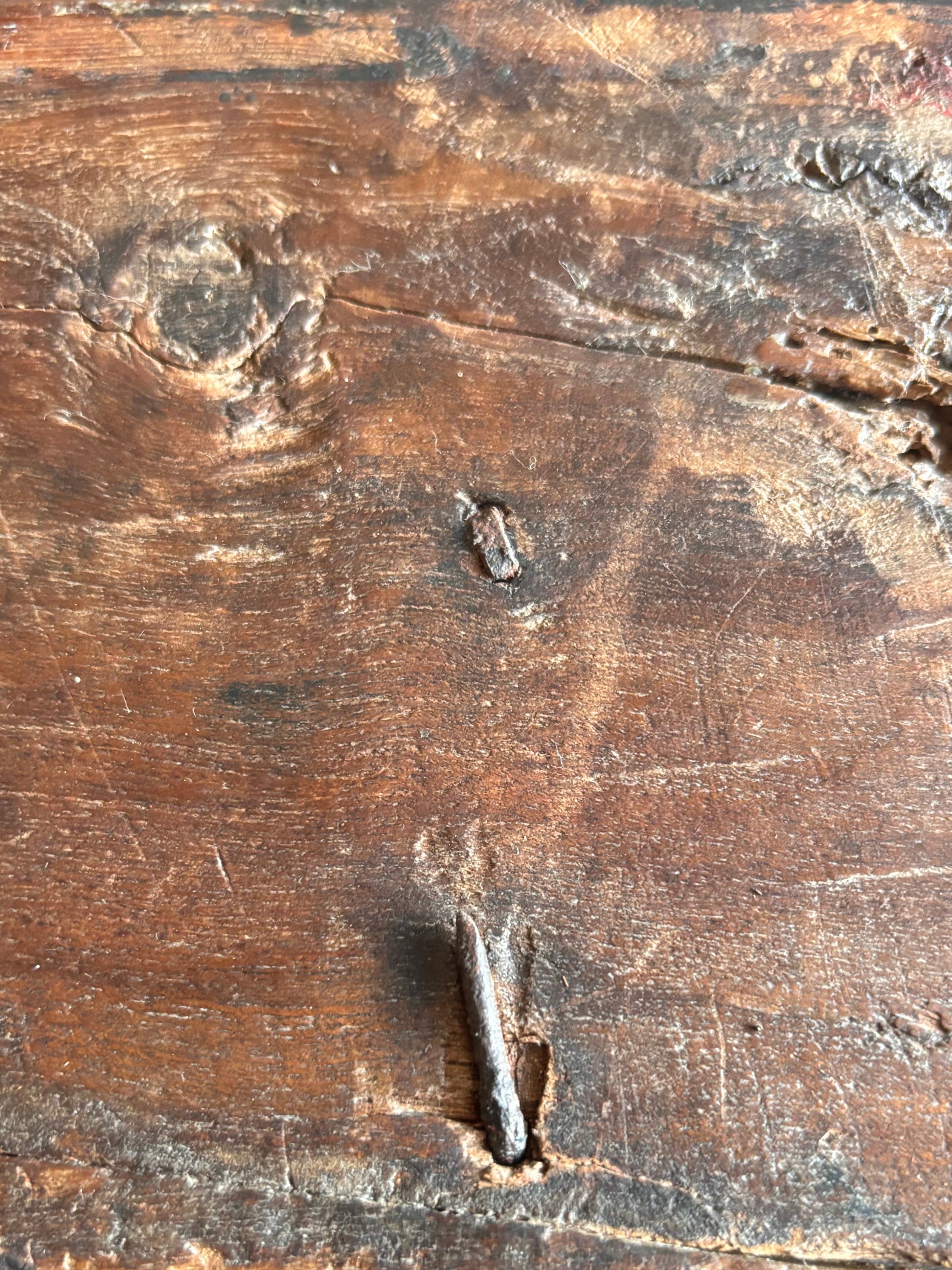 Inside view of antique carved wooden dowry box with forged iron carry handle showing hand forged fixing with newer machine forged repair.