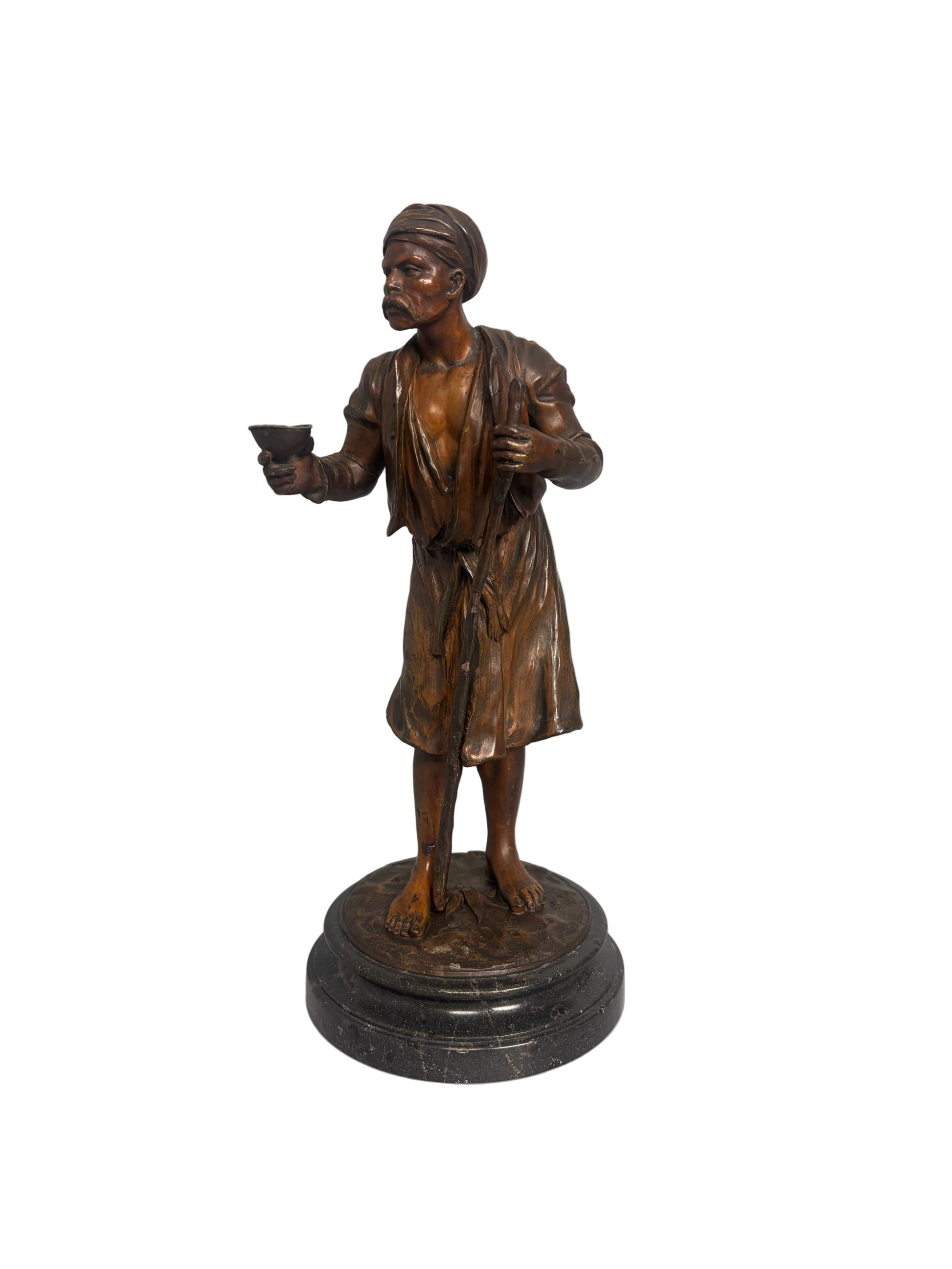 Late 19th-century bronzed metal figure of an Arabian water carrier on a black marble base.