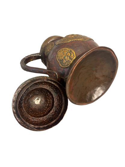 Copper and gilt-brass repoussé Sino-Tibetan style ewer with turquoise inlay and dragon mask medallion, domed lid and spout.