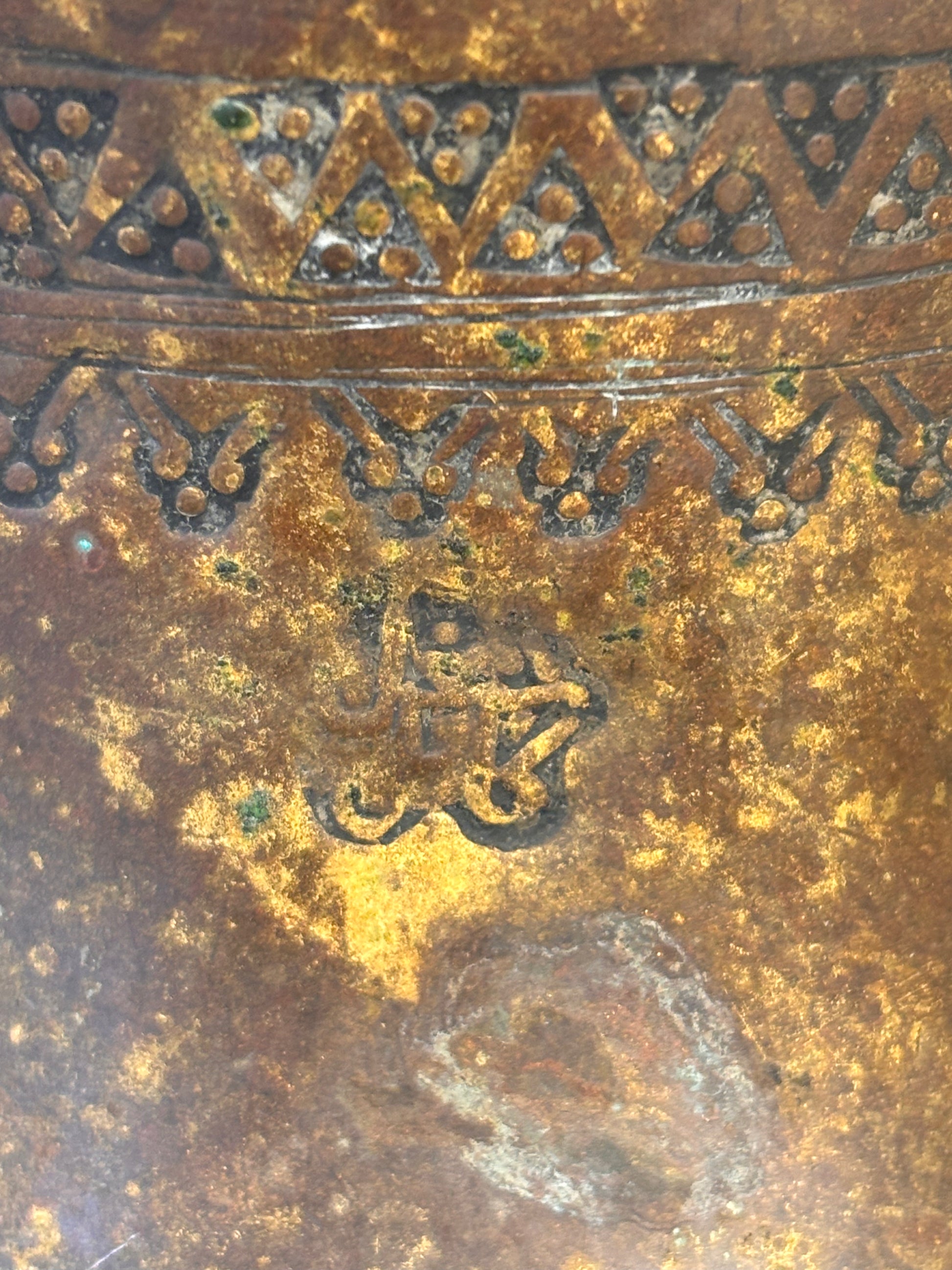 Close up of an Antique Middle Eastern Bedouin brass dallah coffee pot with engraved decoration and domed lid