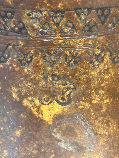 Close up of an Antique Middle Eastern Bedouin brass dallah coffee pot with engraved decoration and domed lid