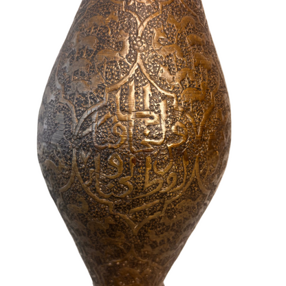 Detail of Persian brass vase showing engraved calligraphy within cartouche