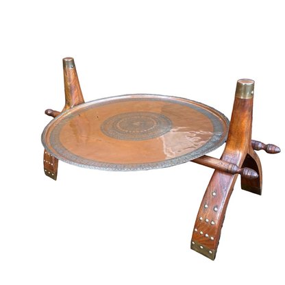Safavid Persian engraved copper tray with calligraphic medallion on mid-century Indian camel saddle wooden stand