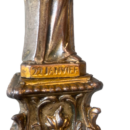 Bronze statue with '22 JANVIER' engraved on the base against a white background