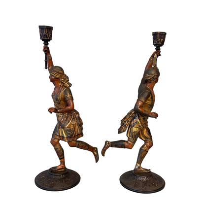 Side view of Victorian Orientalist male and female spelter candlestick figures holding raised torch sconces