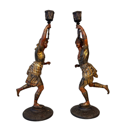 Side view of Victorian Orientalist male and female spelter candlestick figures holding raised torch sconces