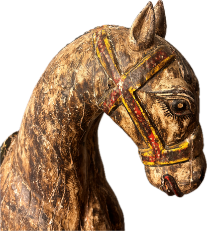 Close-up of carved horse head with painted bridle and stylised eyes