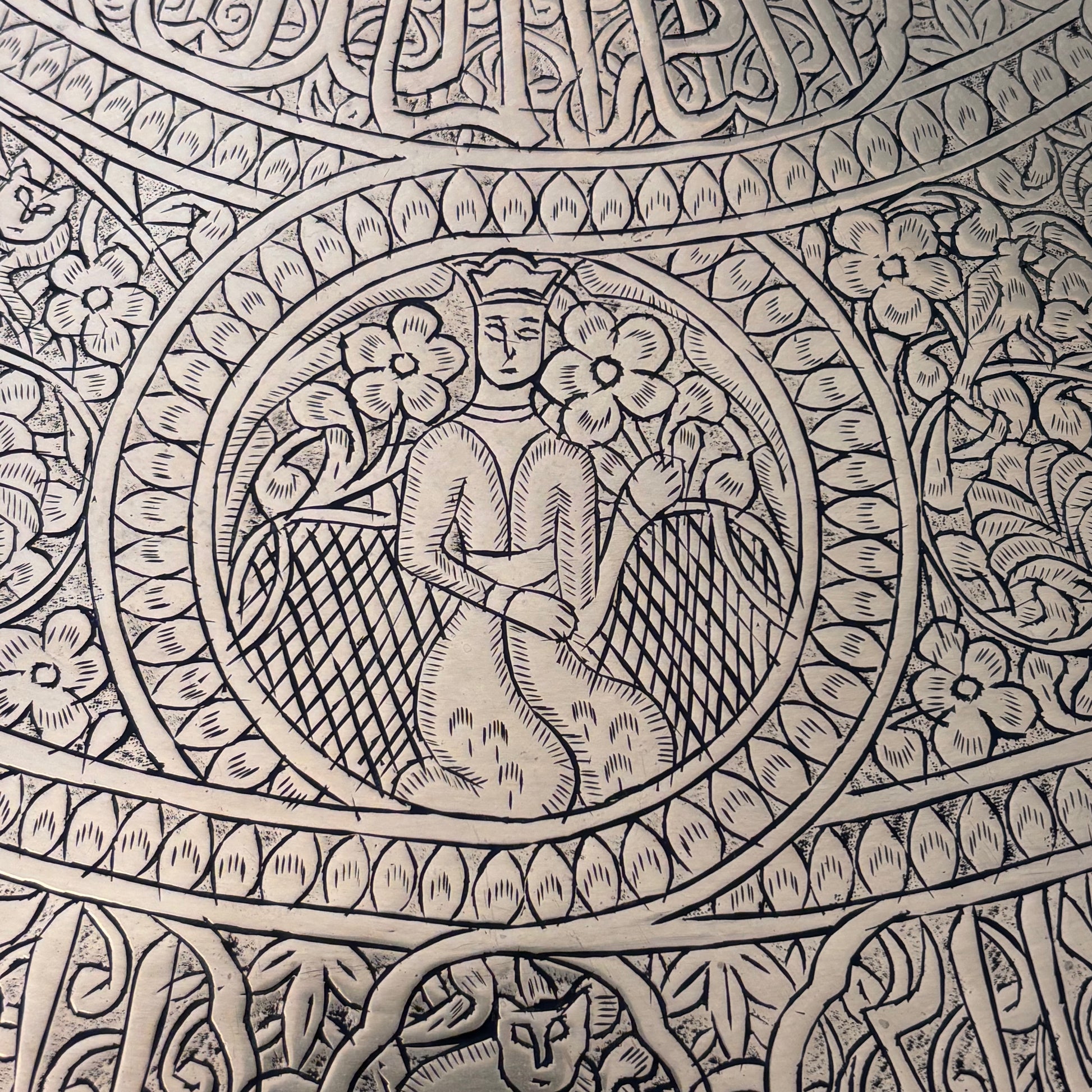 Close-up of Qajar style seated female figures on Persian engraved brass tray