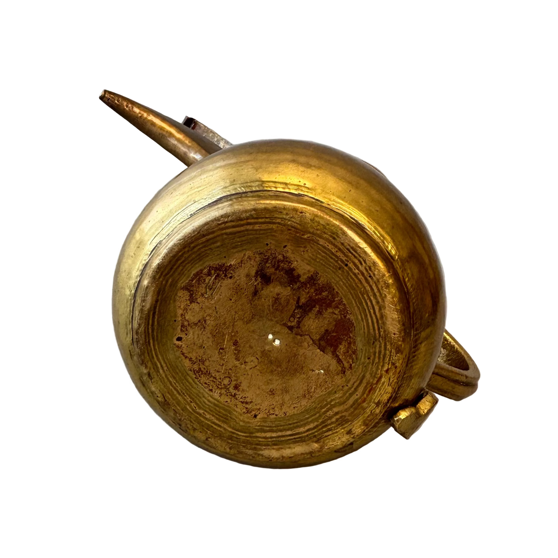Underside of hand-raised brass dallah showing irregular base rings