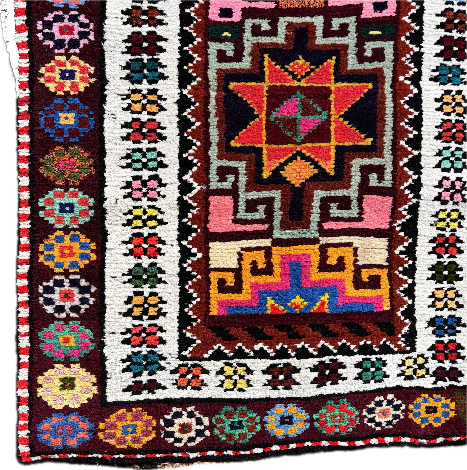 Close up of central star medallion in vivid pink and turquoise wool