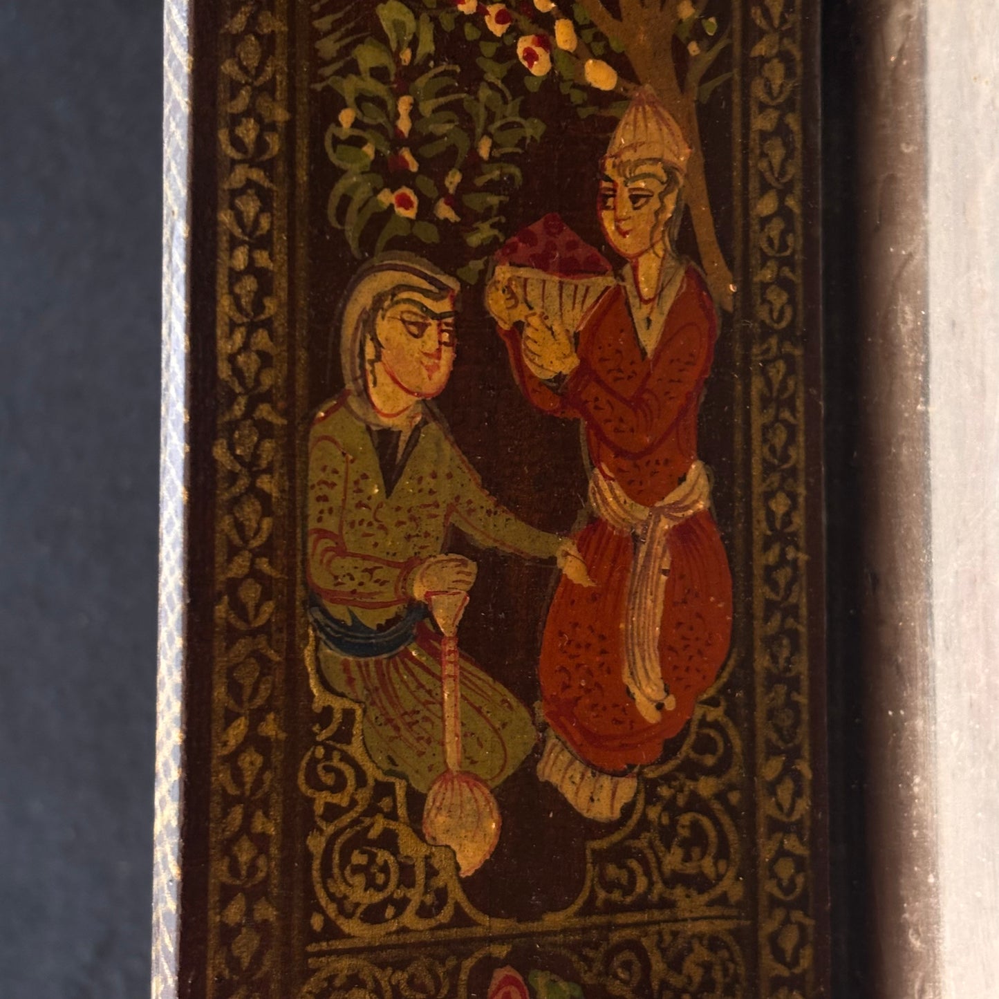 Close-up of hand-painted Persian courtly figures on mirror door