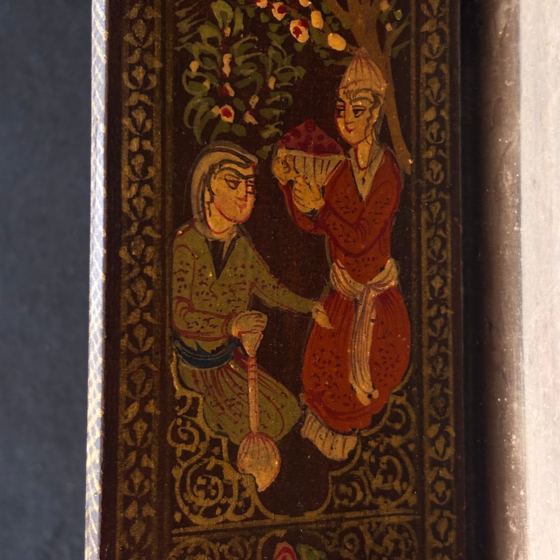 Close-up of hand-painted Persian courtly figures on mirror door