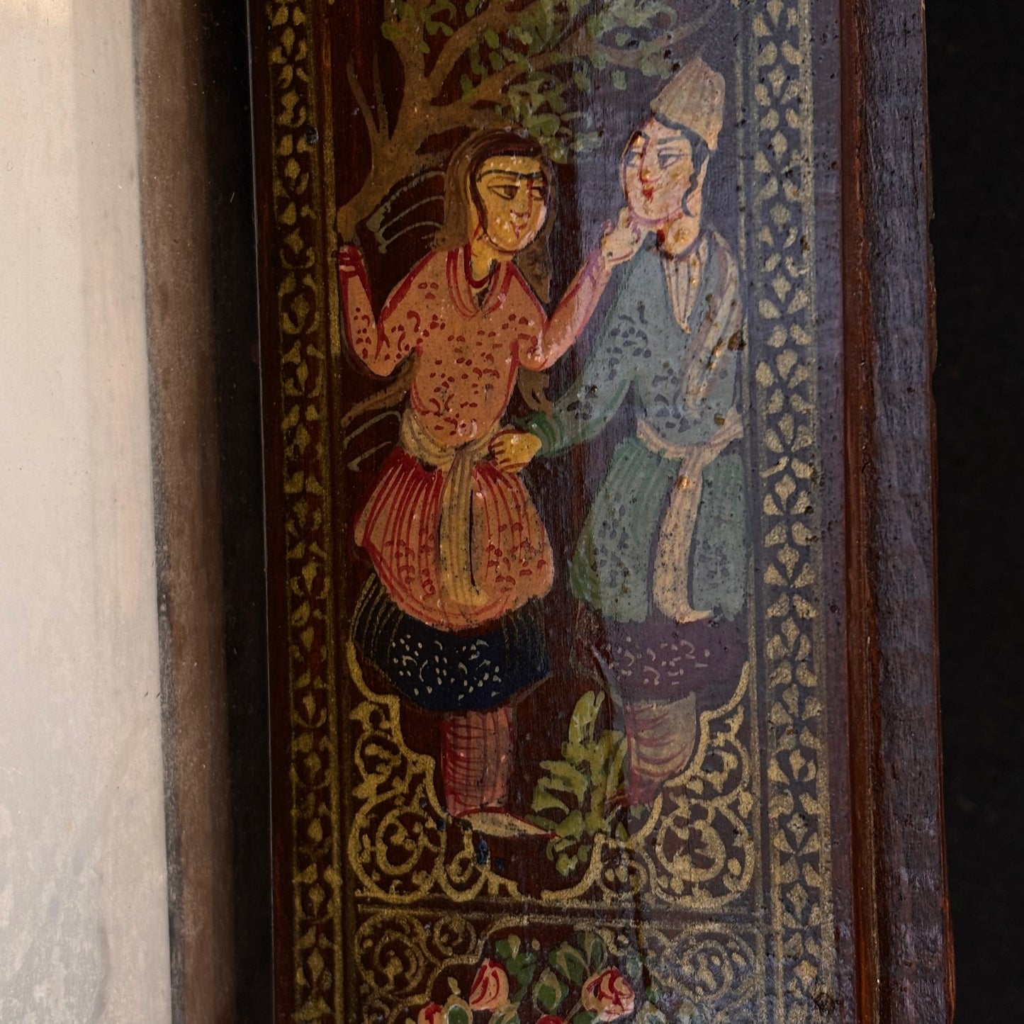 Close-up of hand-painted Persian courtly figures on mirror door