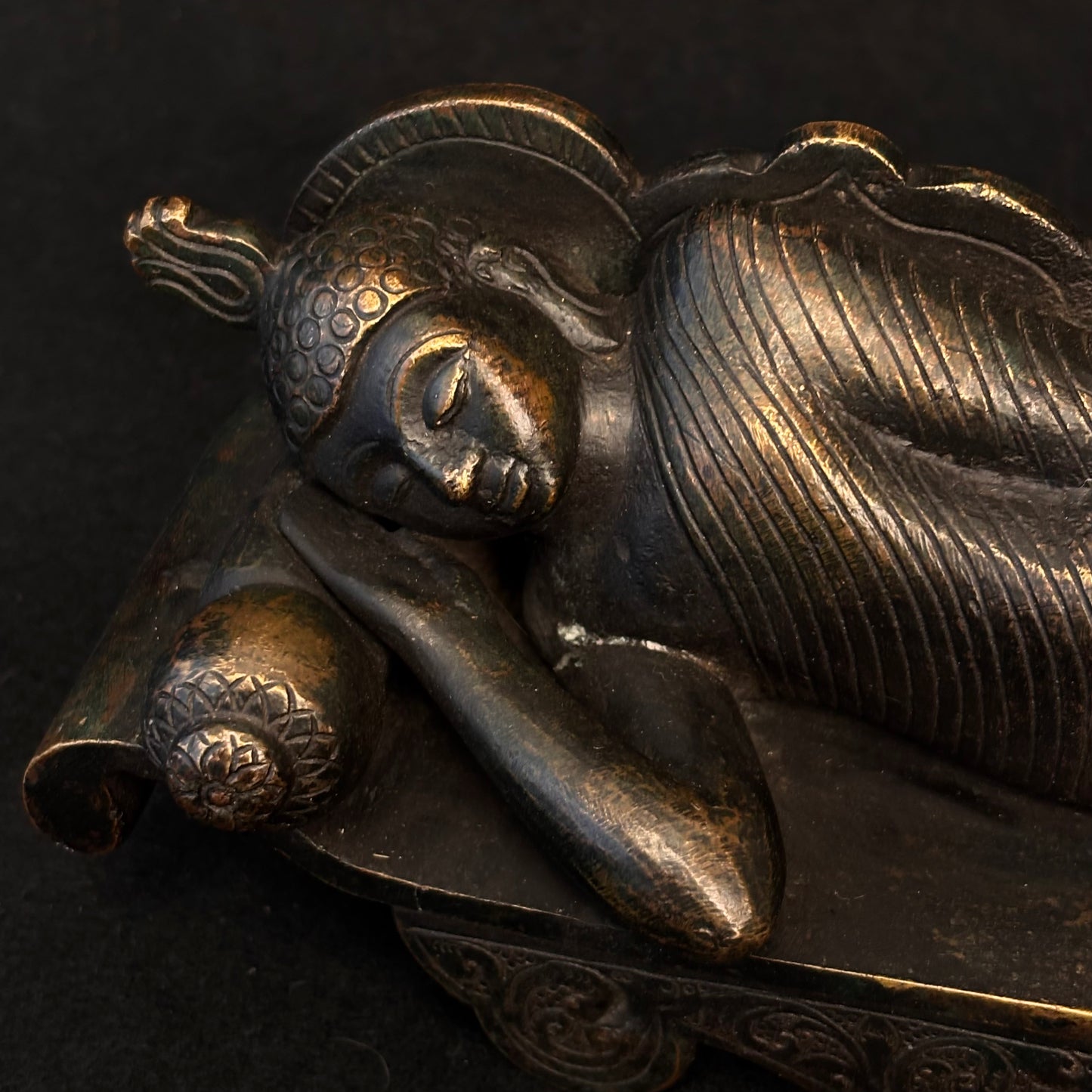 Close-up of Buddha head resting on cylindrical cushion